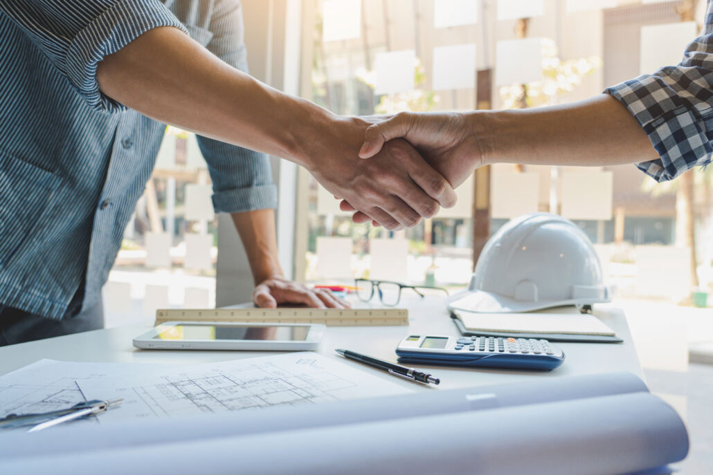 Architect and engineer construction workers shaking hands after finish an agreement in the office construction site
