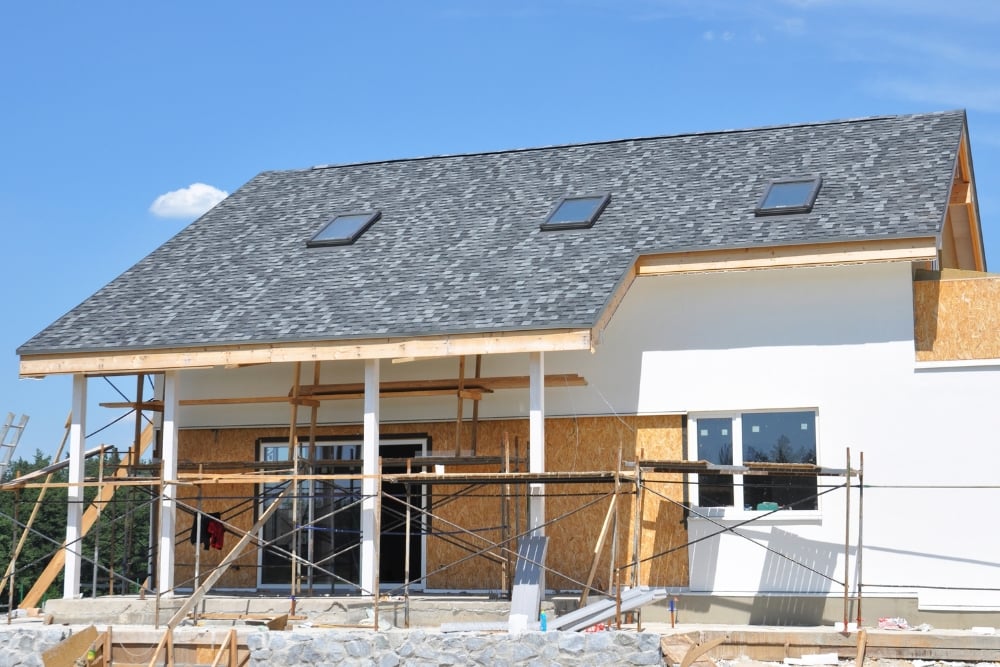 A two-storey house extension under construction with scaffolding out front.
