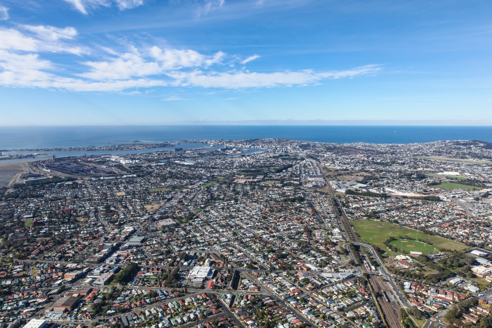 An aerial view of a sprawling coastal city with densely packed residential neighborhoods